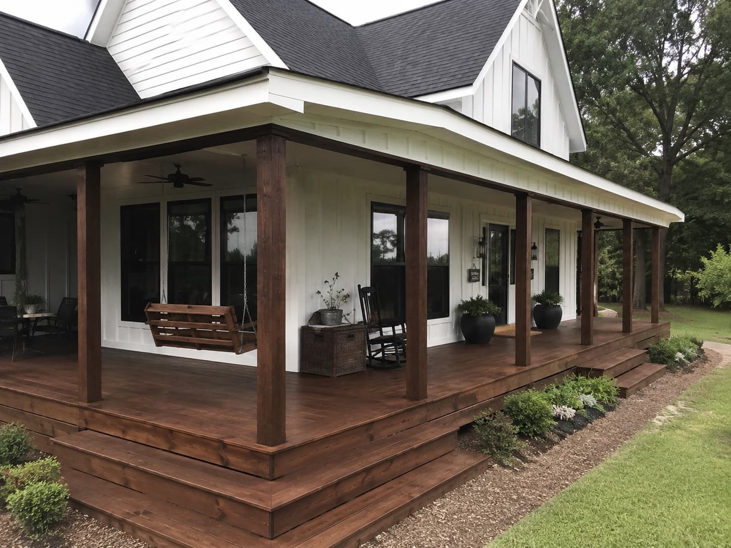 White board-and-batten farmhouse with stained wraparound porch in Blythewood